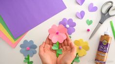 someone is making paper flowers out of construction paper and crafting them with scissors, glue, and felt