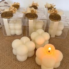 candles are sitting in clear containers on a table