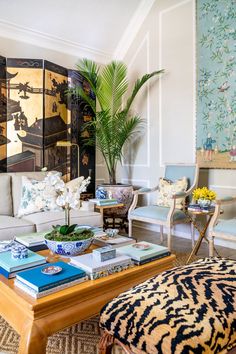 a living room filled with lots of furniture and flowers on top of a fireplace mantel