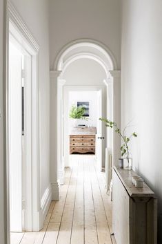 a hallway with white walls and wooden floors