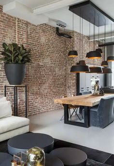 a living room filled with furniture next to a brick wall