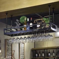 wine glasses and bottles are hanging from the ceiling