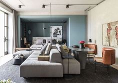 a living room filled with lots of furniture next to a dining table and couches