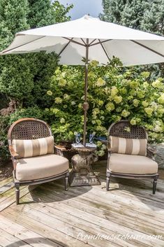 two chairs and an umbrella on a wooden deck