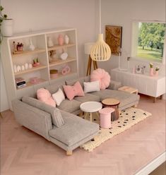 a living room filled with lots of furniture and pink pillows on top of the couch