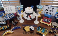 a table topped with lots of cupcakes and cake decorating items on top of a wooden table