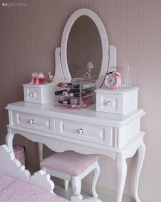 a white dressing table with a mirror and stool