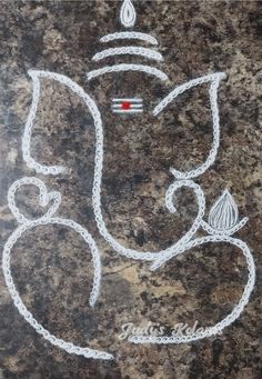 a drawing of the face of ganesh on a granite surface with white chalk writing