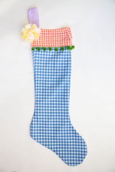 a blue and white checkered christmas stocking with a flower on the top is shown