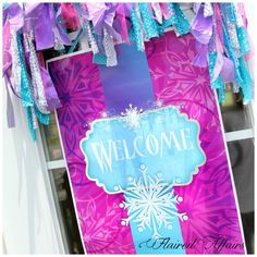 a welcome sign hanging from the side of a window with ribbons and streamers around it