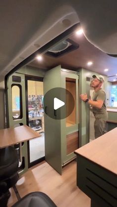 a man standing in front of a kitchen next to a table