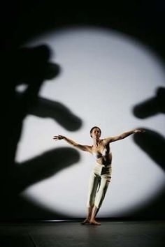 a person standing in front of a shadow on a wall with their arms spread out