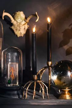 some candles are sitting on a table next to an hourglass and other items that have been placed around it