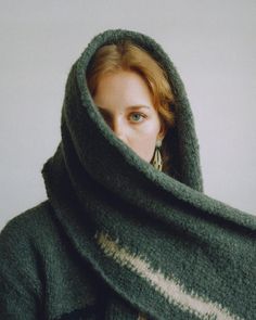 a woman with red hair wearing a green scarf