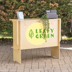 a wooden bench with a plant growing out of it's top and the words leafy green on it