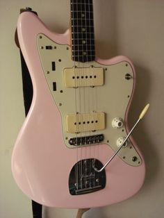 a pink guitar hanging on the wall