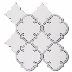 four pieces of white tile with an intricate design