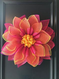 a pink and yellow flower on a black frame