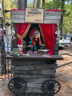 an old fashioned wooden cart with a doll on it's top and decorations around the outside