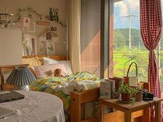 a bedroom with a bed, desk and window looking out onto a field outside the room