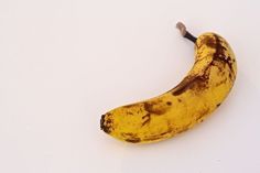 a ripe banana sitting on top of a white table