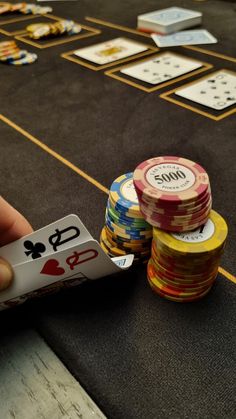 playing cards and poker chips on a black carpeted floor with yellow lines around them