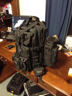 several pieces of luggage sitting on top of a wooden desk