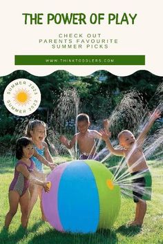 children playing in an inflatable ball with sprinkles on the grass