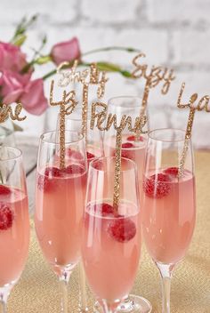 three champagne flutes with raspberries in them and the words happy birthday on top