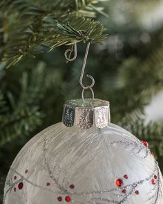 an ornament hanging from a christmas tree with red and white beads on it