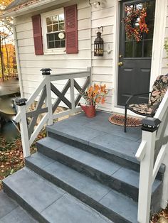 a porch with steps leading up to the front door and patio area, in fall