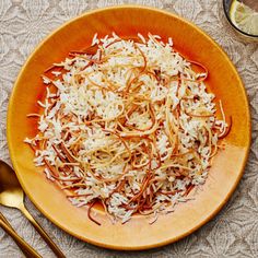 a plate full of shredded cheese on top of a table with spoons and utensils