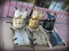 five different types of armor on display in front of a fenced area with iron bars