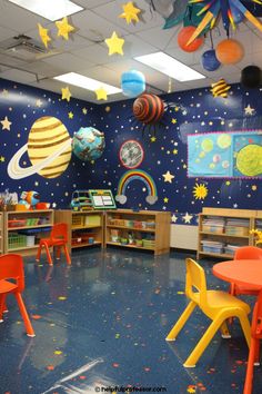 a classroom with space themed walls and colorful chairs