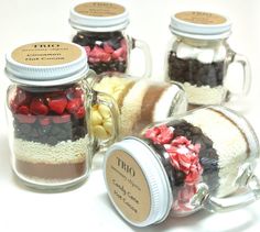 four mason jars filled with different types of candies and chocolates, all in the same jar