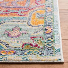 an area rug on the floor with wood floors in the background and a colorful floral design