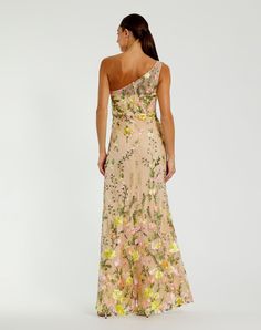 a woman in a long dress with flowers on the side and one shoulder, looking back