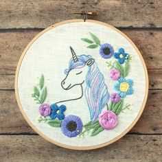 a unicorn with flowers in the hoop on a wooden surface