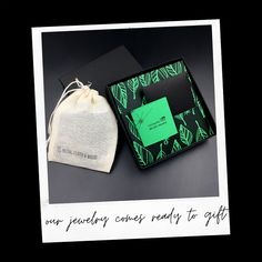 a green and black box with a note on it next to a drawstring bag