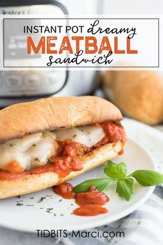 a meatball sandwich with tomato sauce and basil on a plate next to an instant pot creamy meatball sandwich