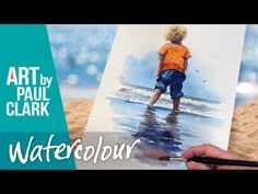 a person is painting on the beach with watercolors and sand in front of them