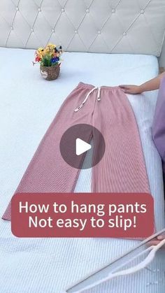 a woman laying on top of a bed next to an object that says how to hang pants not easy to slip