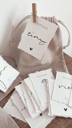 small white cards with black ink on them are sitting next to a drawsack bag