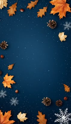 an overhead view of autumn leaves and pine cones on a blue background with snowflakes