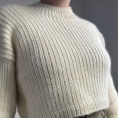 a mannequin is wearing a white sweater and skirt with buttons on the waist