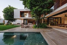 an outdoor swimming pool in front of a house