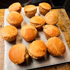 twelve freshly baked muffins on a baking sheet