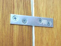 a close up of a metal door handle on a wooden door with two screws