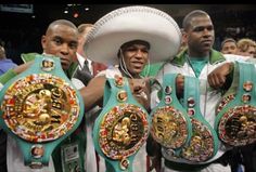 two men holding up their belts in front of the camera while wearing sombreros