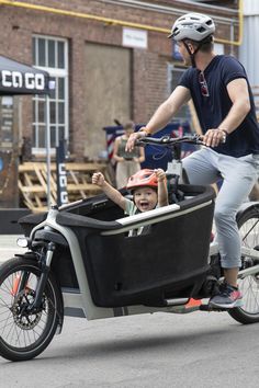 a man riding a bike with a child in the back